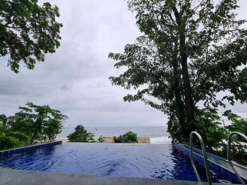 LilaHome in Bohol Philippines的一座种有树木和海洋的游泳池