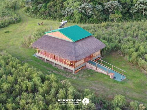 伊图萨因戈Wild Wetlands Lodge的享有带草屋顶的大型建筑的顶部景色