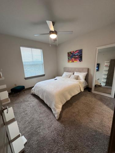沃思堡Stylish-homes的一间卧室配有一张大床和吊扇