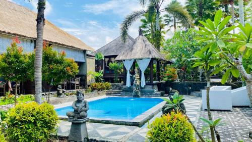 帕洋安Dong Loka Guesthouse Bali的一个带雕像和凉亭的度假游泳池