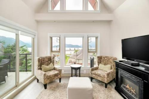 哈里森温泉Penthouse Lake Home - 3BR w/Amazing View & Deck!的客厅设有壁炉和平面电视。