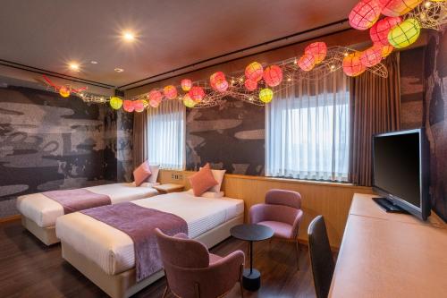 青森ART HOTEL Aomori的酒店客房设有两张床和一台平面电视。