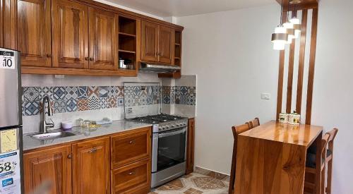 奥塔瓦洛Kimsa Wasi I的厨房配有木制橱柜和炉灶烤箱。