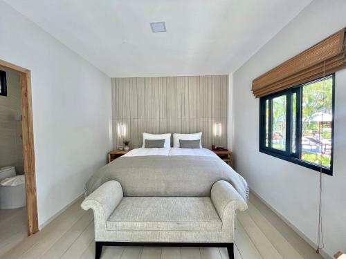 苏梅岛Moorea Boutique Resort Samui的卧室配有床、椅子和窗户。