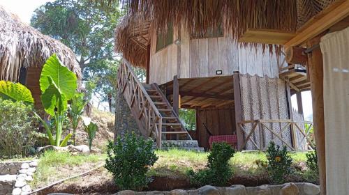 圣玛尔塔ECOCABAÑAS DIOSA JAGUAR tayrona的楼梯通往带稻草屋顶的房子