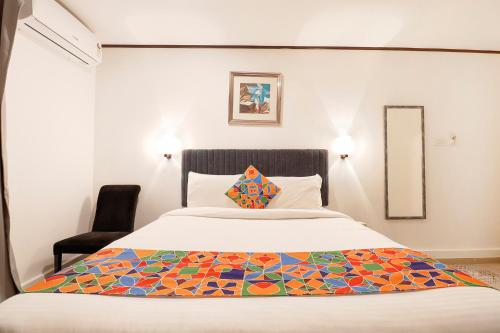 班加罗尔FabHotel Park Inn Indiranagar的一间卧室,床上有五颜六色的被子