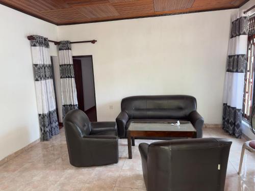 RambukkanaRelax Home Pinnawala的客厅配有真皮沙发和桌椅
