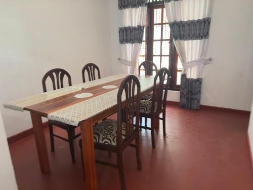 RambukkanaRelax Home Pinnawala的一间带桌椅和窗户的用餐室