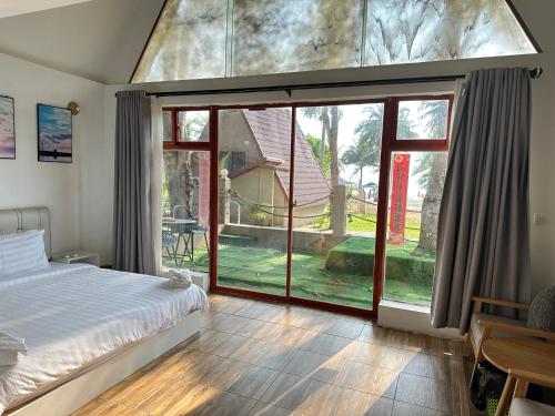 Phumĭ Kaôh RŏngKoh RhongSunshine Resort的一间卧室设有一张床和一个大窗户