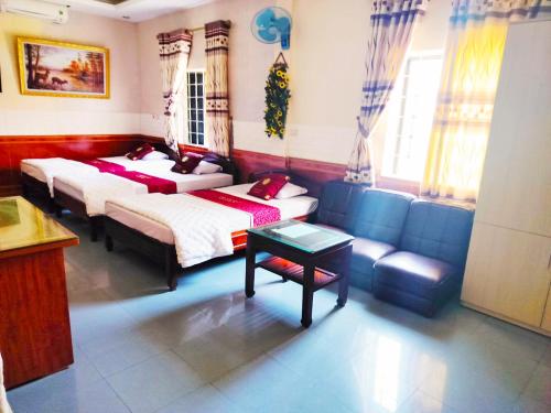 Xuân ÐàiGRAD Hoa Do Hotel的一间带两张床和一张沙发的客厅