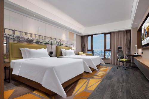 广州广州洛溪希尔顿欢朋酒店的酒店客房配有两张床和一张书桌