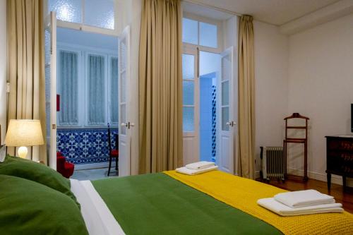 波尔图Casa Velha Guesthouse的一间卧室设有绿色和黄色的床和窗户。