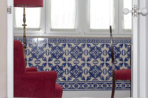 波尔图Casa Velha Guesthouse的客厅配有红色椅子和蓝色及白色瓷砖