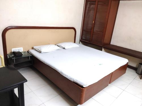 哥印拜陀Hotel Diana Gandhipuram的一间卧室配有带白色床单和枕头的床。
