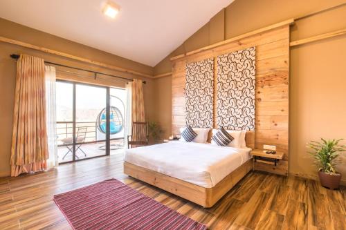 博卡拉Sunshine Resort Pokhara的一间卧室设有一张大床和一个大窗户