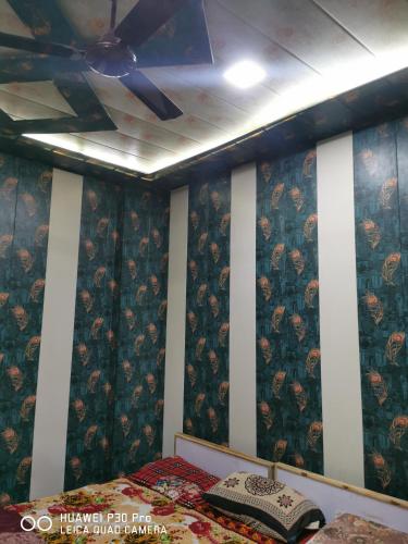 马图拉Kadiya dharamshala的一间卧室配有吊扇和一张床