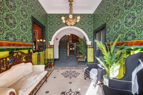 维多利亚山Victoria and Albert Guesthouse的客厅设有绿色的墙壁和吊灯。