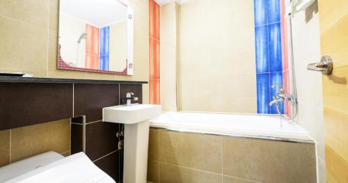 泗川Sacheon Tourist Hotel的一间带水槽、卫生间和镜子的浴室