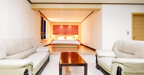 泗川Sacheon Tourist Hotel的客厅配有2张白色沙发和1张床