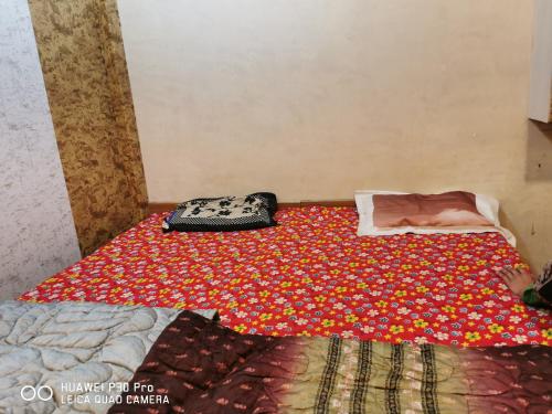 马图拉Kadiya dharamshala的一间卧室配有一张床上的鲜花毯子