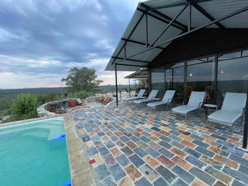 奥奇瓦龙戈Aloegrove Safari Lodge的一个带椅子和遮阳伞的室外游泳池