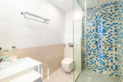 迪拜LUX - Opulent Island Suite 4的一间带卫生间和玻璃淋浴间的浴室