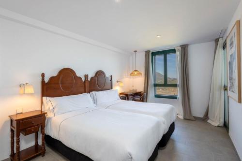 扎哈拉Hotel Tugasa Arco de la Villa的卧室设有一张白色大床和一扇窗户。