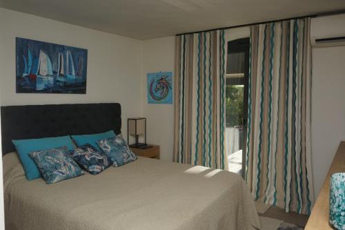 圣马克西姆Villa les Cades的一间卧室配有一张带蓝色枕头的床和一扇窗户。