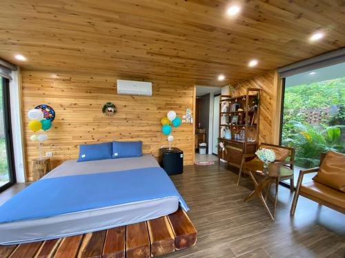 Sóc SơnSóc Sơn Homestay - Bird House的一间卧室设有一张床和木墙