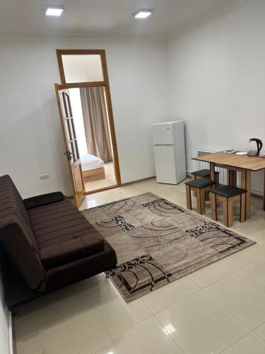 久姆里Mtour Apartment的客厅配有沙发和桌子