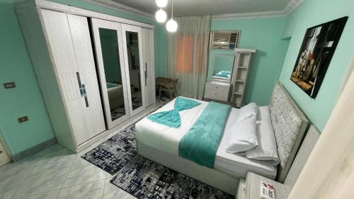 开罗New Cozy Apartment 5 Minutes away from Cairo Airport and all Amenties的一间设有床铺的卧室,位于一间拥有蓝色墙壁的房间