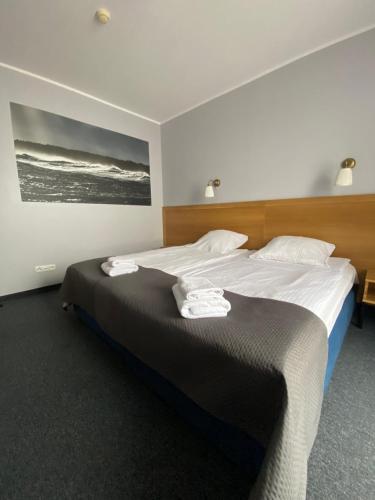 格但斯克加利恩酒店的一间卧室配有一张大床和毛巾