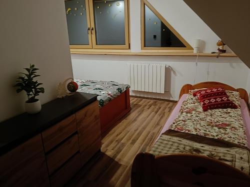 拉伊恰Domek u Sołtyska的一间卧室设有两张床、一个梳妆台和窗户。