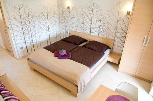 迪瓦查Apartmaji Zenja的一间卧室配有一张床铺,床上装有紫色托盘
