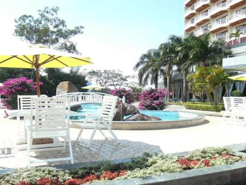 波来古市HAGL Hotel Gia Lai的喷泉旁的一组椅子和一把伞