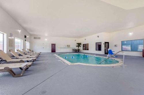 Copperas CoveComfort Suites的大型游泳池,位于带椅子的大房间