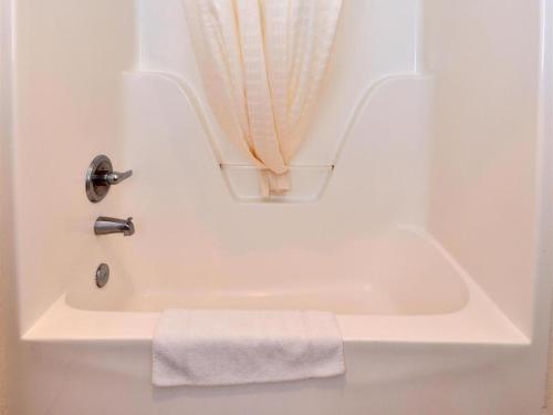 Americas Best Value Inn Smackover的浴室内带毛巾的白色浴缸