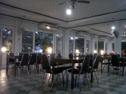 Ban Nong TaoKasem Garden Hotel Surin的用餐室设有桌椅和窗户。
