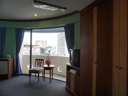 合艾Tanaphat Hatyai Hotel的客房设有电视和美景窗户。