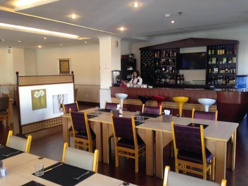 奥隆阿波Grand Hoyah Hotel的一间带桌椅的餐厅和一间酒吧