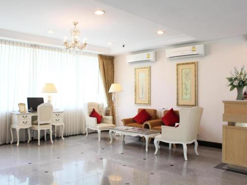 曼那Romance Hotel Srinakarin的客厅配有沙发、椅子和书桌