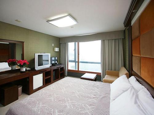 江陵市Goodstay Soo Hotel的酒店客房,配有床和电视