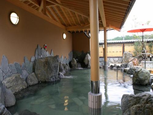 武雄市Nanaironoyu Hotel的一座房子里一片带岩石的水池