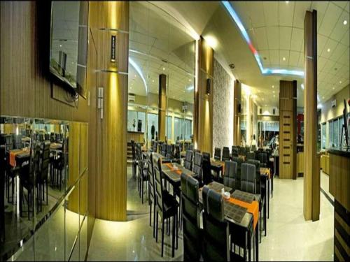 ParitBenteng Hotel Pekanbaru的大楼内带桌椅的用餐室