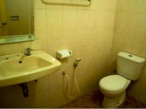 BendunganKing Hotel的浴室配有白色卫生间和盥洗盆。