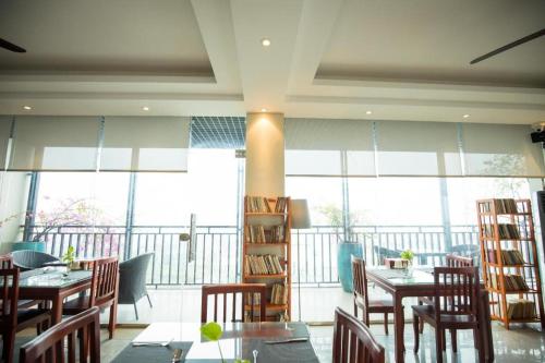 Ða HộiGia Bao Hotel Bac Ninh的用餐室设有桌椅和窗户。