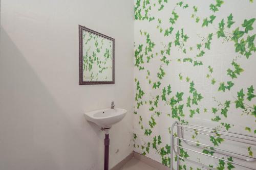 珀尼达岛Omah Nusa Villa RedPartner的浴室设有水槽,墙上有绿叶