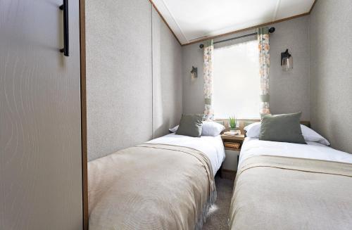 彭里斯Ullswater Holiday Park - Static 5的小型客房 - 带2张床和窗户