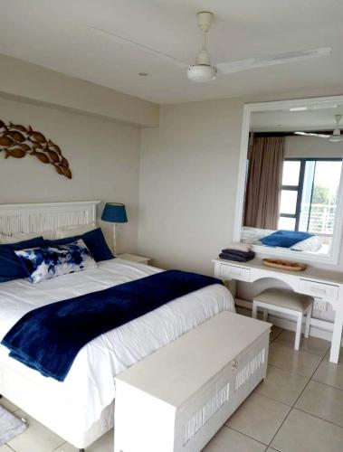 马盖特Indigo Bay 29的卧室配有一张白色大床和一张书桌