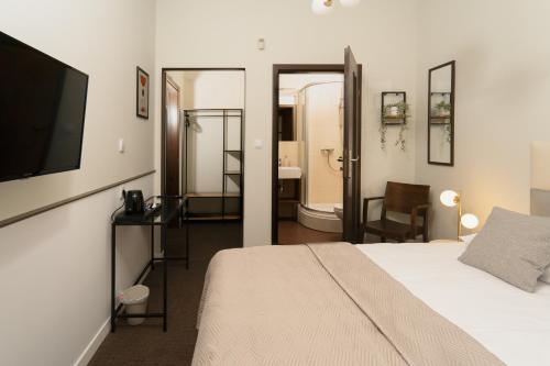 波兹南Expo Apartments的一间卧室配有一张床、一台电视和一间浴室。